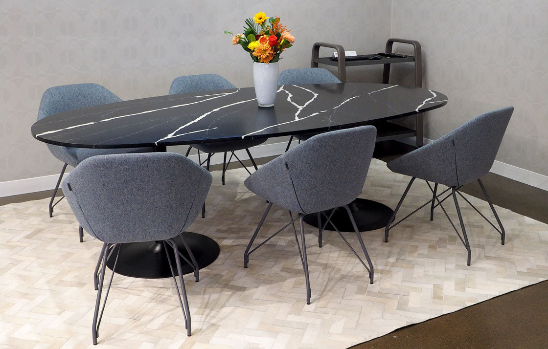 Six low back grey lounge chairs with four leg frame base set around a custom designed dining table