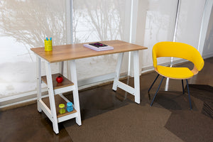 White and oak 2-shelf student desk beside a yellow chair.