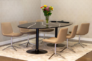 Custom-made Caeserstone oval table surrounded by six chairs in cafe latte upholstery