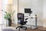 Load image into Gallery viewer, Back view of black Nuova work chair in front of Sutton height-adjustable desk
