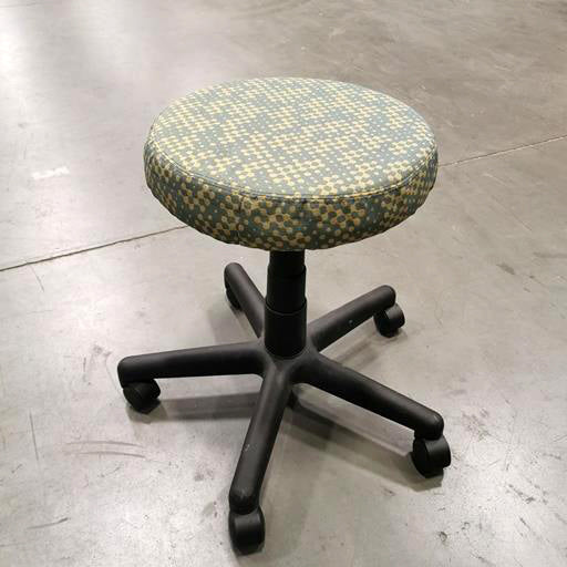 Teknion spinner stool in green and yellow patterned fabric with black base and 5-star  hard casters